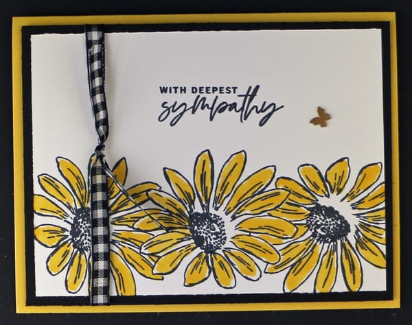 The addition of black and white gingham ribbon and a metallic accent is an easy way to step up a handmade card with cheerful yellow stamped sunflowers.